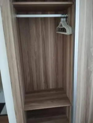 a closet with a wooden door with a hanger at Hideaway Rosa Parc Mohammedia in Mohammedia