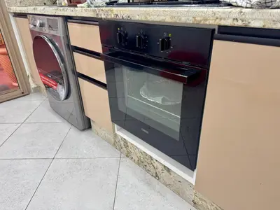 a black oven in a kitchen next to a washing machine at Hideaway Rosa Parc Mohammedia in Mohammedia