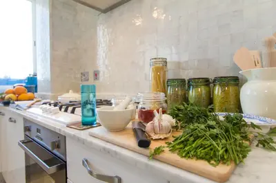 a kitchen counter with jars and vegetables on a cutting board at Appartement Lilia in Casablanca