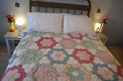 a bed with a colorful quilt on it with two lamps at Appartement Lilia in Casablanca
