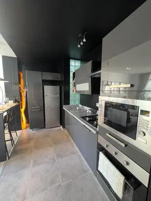 a kitchen with black walls and stainless steel appliances at Stay IN GAUTHIER studio M in Casablanca