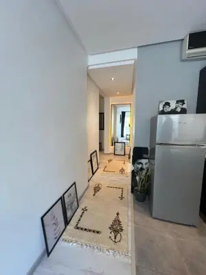 a living room with a refrigerator and two rugs at Stay In GAUTHIER studio s in Casablanca