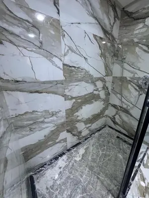 a bathroom with a marble shower with a glass door at Studio au parc calme in Mohammedia