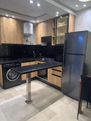 a kitchen with a refrigerator and a table in it at Studio au parc calme in Mohammedia