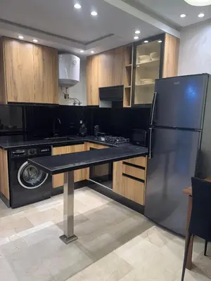 a kitchen with a black refrigerator and a dishwasher at Studio au parc calme in Mohammedia