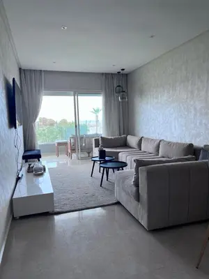 a living room with a couch and a table at Sidi Rahal Blue View 3, front mer, accès plage 1 Piscine in Sidi Rahal