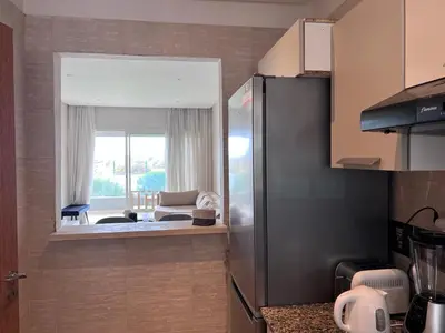 a kitchen with a view of a living room at Sidi Rahal Blue View 3, front mer, accès plage 1 Piscine in Sidi Rahal