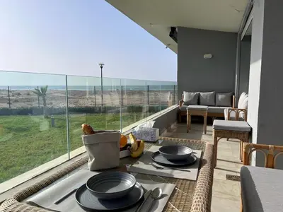 a living room with a table and a large window at Sidi Rahal Blue View 3, front mer, accès plage 1 Piscine in Sidi Rahal