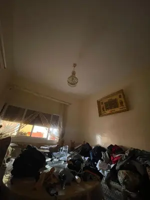 a room with a pile of clothes on a bed at guzman appartement in Sidi Yahia az Zaʼer