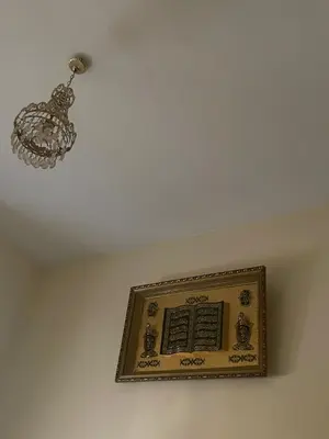 a ceiling with a chandelier and a plaque on it at guzman appartement in Sidi Yahia az Zaʼer