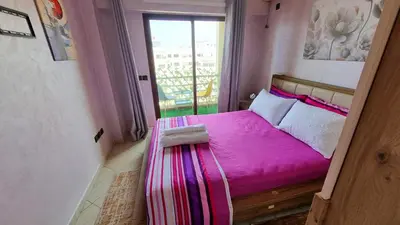 a small bedroom with a pink bed with a balcony at appartement central in Casablanca