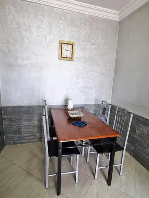 a dining room table with chairs and a clock on the wall at appartement central in Casablanca