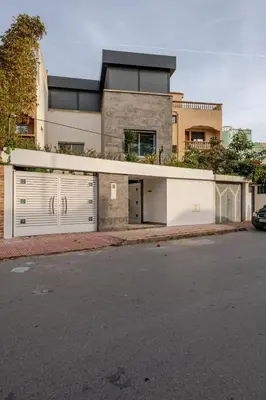 a house with two garage doors on a street at Villa Evasion Rabat Beach in Rabat