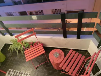 two red chairs and a potted plant on a balcony at studio casa in Casablanca