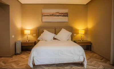 a bedroom with a large bed with two lamps on two tables at Appartement entier 2 chambres marina avec vue panoramique mer in Casablanca