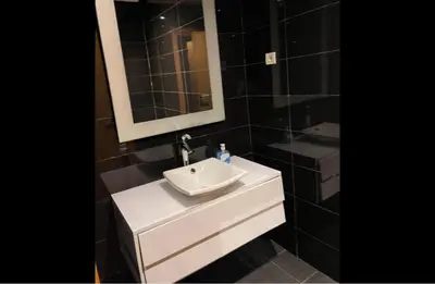 a bathroom with a white sink and a mirror at Appartement entier 2 chambres marina avec vue panoramique mer in Casablanca