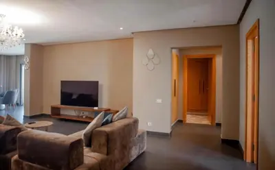 a living room with a couch and a tv at Appartement entier 2 chambres marina avec vue panoramique mer in Casablanca