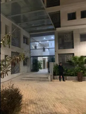 a man walking in front of a building at Appartement entier 2 chambres marina avec vue panoramique mer in Casablanca