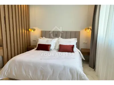 a bedroom with a white bed with two red pillows at Youradress Casablanca - Maarif in Casablanca