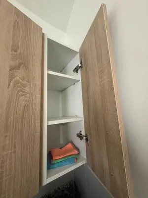a closet with a wooden door and some towels at Appartement Casablanca près de la mer in Dar Bouazza