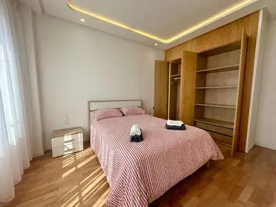 a bedroom with a bed with pink sheets and a book shelf at Luxury Oasis Apartment -Rooftop Pool & Home Cinema in Casablanca