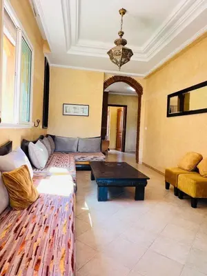 a living room with a couch and a table at Joli appartement Ricoflores El Mansouria in O Ben Slimane