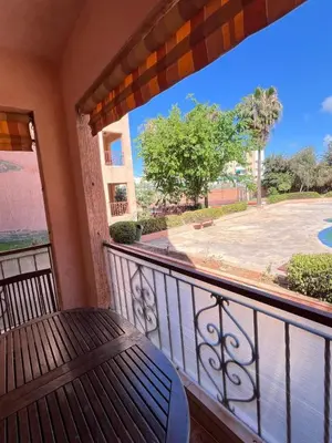 a balcony with a table and a view of a courtyard at Joli appartement Ricoflores El Mansouria in O Ben Slimane