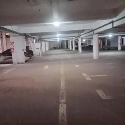 an empty parking lot in a parking garage at night at Joli appartement Ricoflores El Mansouria in O Ben Slimane
