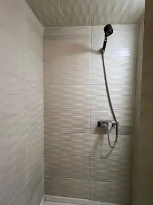 a shower with a shower head in a bathroom at Joli appartement Ricoflores El Mansouria in O Ben Slimane