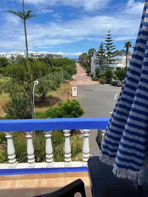 a balcony with a view of a street and a beach at Chez Bouchra in Mansouria