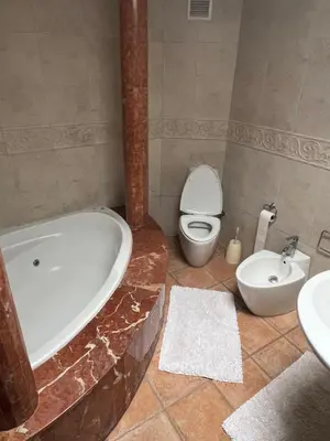 a bathroom with a tub and a toilet and a sink at Chez Bouchra in Mansouria