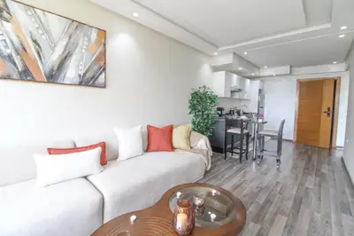 a living room with a couch and a table at Riviera Escape - Appart Neuf Climatisé avec Balcon à Maarif Anfa in Casablanca