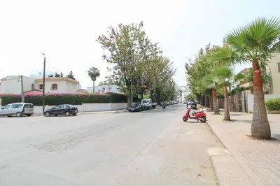 a scooter parked on the side of a street with palm trees at Riviera Escape - Appart Neuf Climatisé avec Balcon à Maarif Anfa in Casablanca