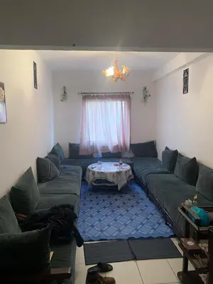 a living room with a couch and a table at Tms in Sidi Yahia az Zaʼer