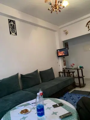 a living room with a green couch and a table at Tms in Sidi Yahia az Zaʼer