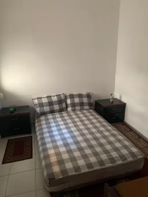 a bed in a room with two nightstands and a bed with a pl at Tms in Sidi Yahia az Zaʼer