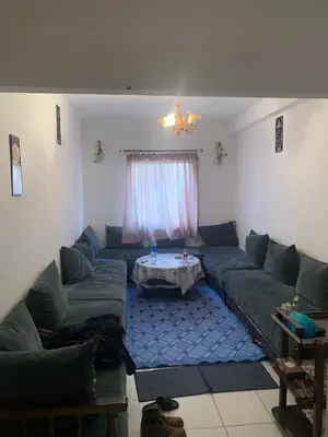 a living room with couches and a table in it at Tms in Sidi Yahia az Zaʼer