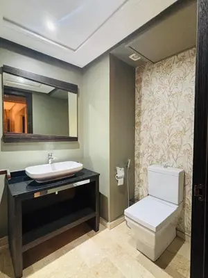 a bathroom with a sink and a toilet and a mirror at Urban square - comfortable, sunny, and fully equipped in Casablanca