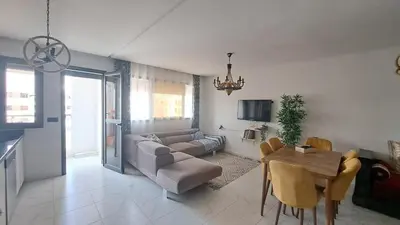 a living room with a couch and a table at Bel appartement près de la plage pour Famille in El Harhoura
