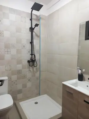 a bathroom with a shower and a toilet and a sink at Bel appartement près de la plage pour Famille in El Harhoura