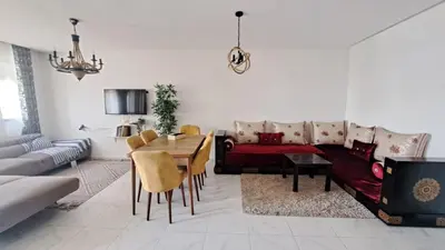 a living room with a couch and a table at Bel appartement près de la plage pour Famille in El Harhoura