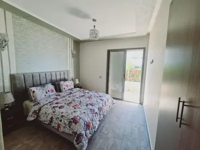 a bedroom with a bed with a floral bedspread at Résidence marbella mansouria in Mansouria