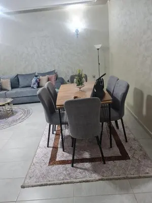 a dining room table with chairs and a couch at Résidence marbella mansouria in Mansouria