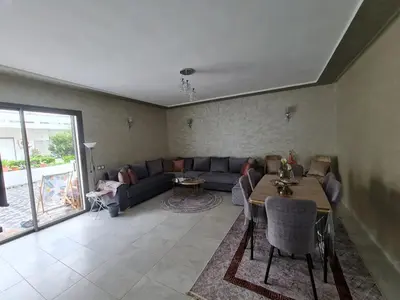a living room with a couch and a table at Résidence marbella mansouria in Mansouria