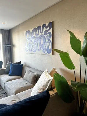 a living room with a couch and a painting on the wall at Le Balcon du Port in Casablanca