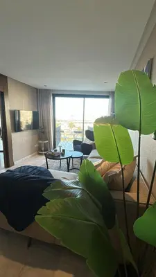 a living room with a large green plant in the foreground at Le Balcon du Port in Casablanca