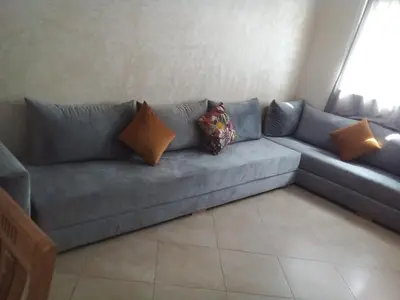a blue couch with pillows sitting in a living room at Le calme de Bouznika in Bouznika