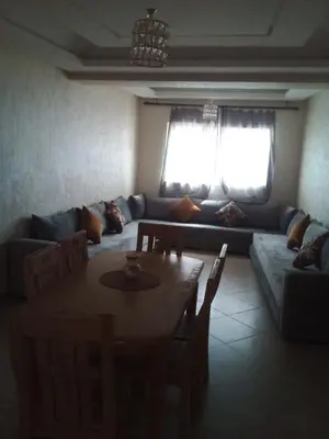 a living room with a table and a couch at Le calme de Bouznika in Bouznika