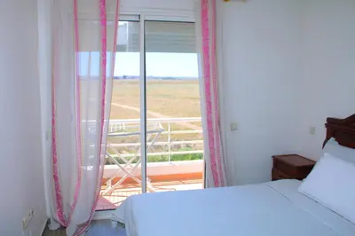 a bedroom with a bed and a window with a view at Bouznika H18 in Bouznika