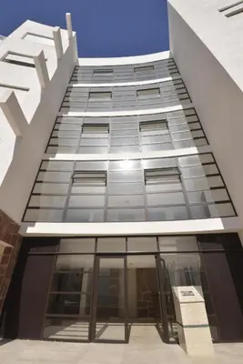 a tall building with a lot of glass windows at Bouznika H18 in Bouznika